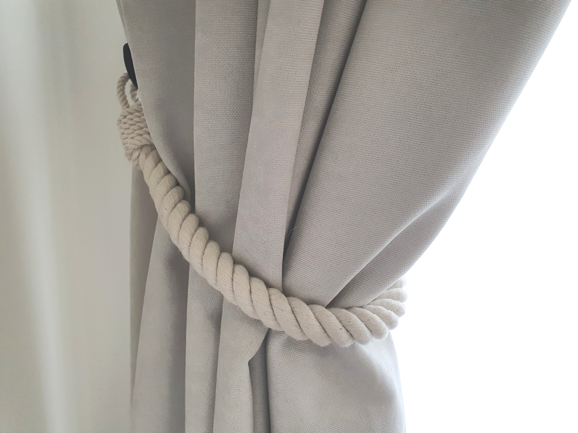 White curtain with a rope tieback blind