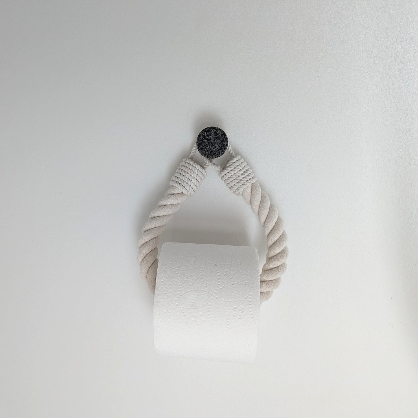 White paper towel roll hanging on a white wall