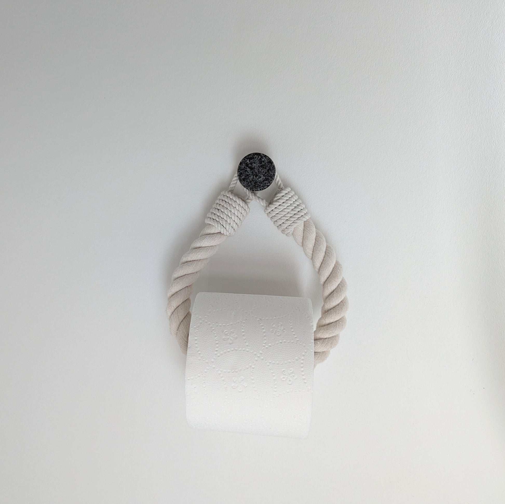 White paper towel roll hanging on a white wall
