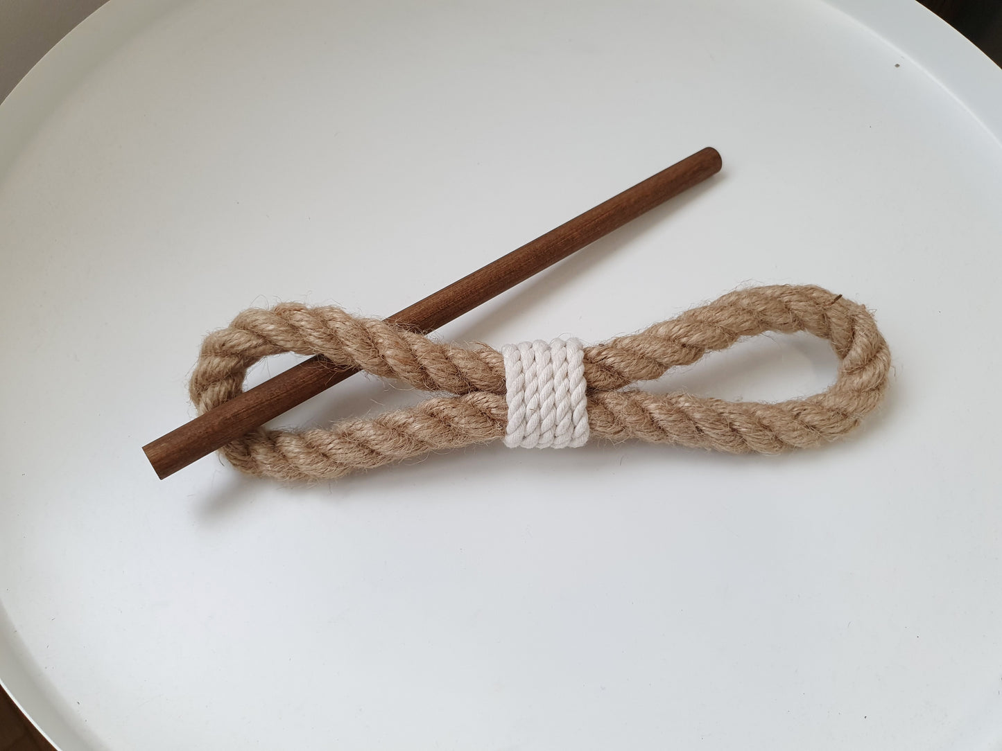 Rope tieback around a stick on a white plate