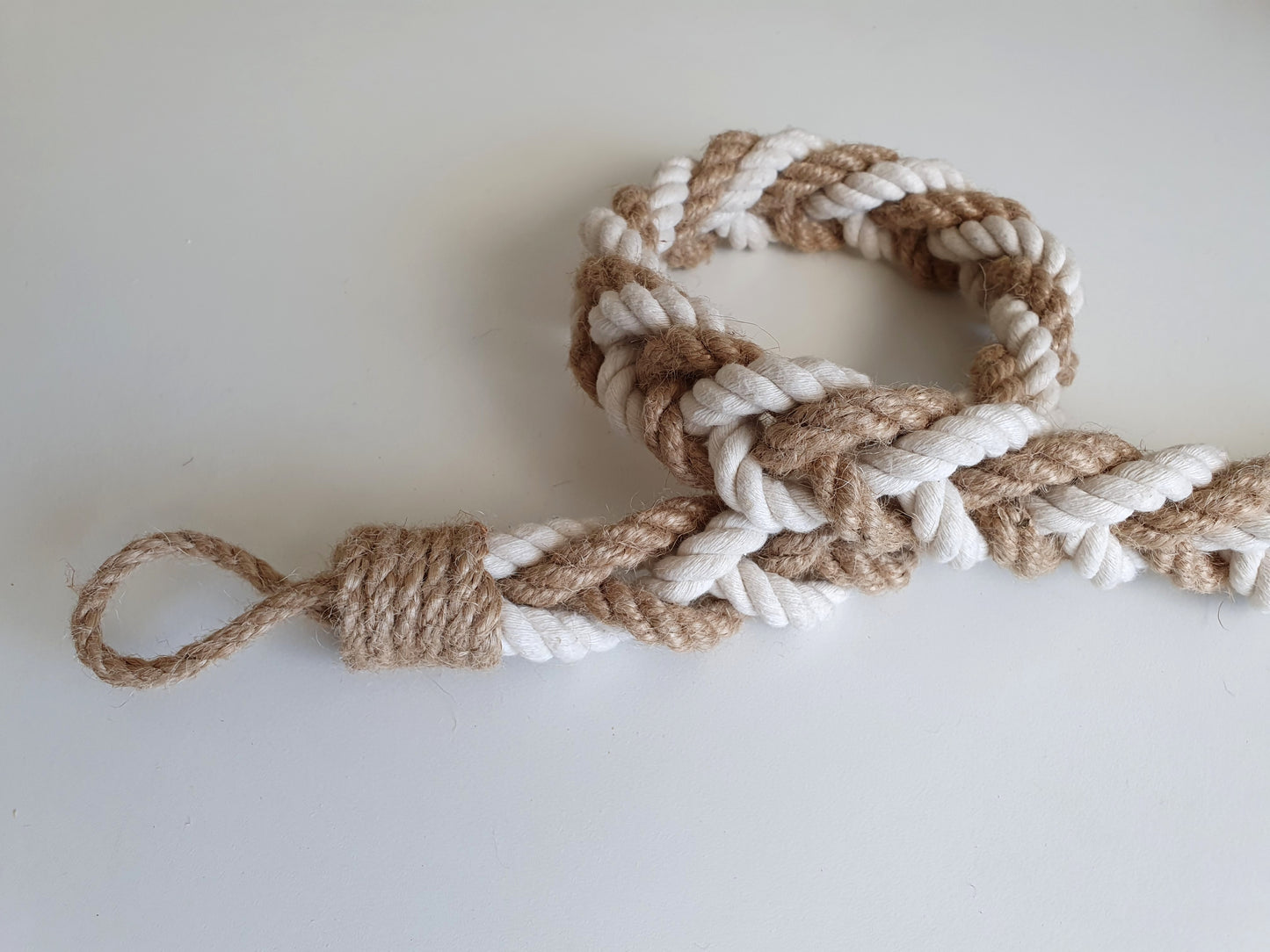 Nautical-style rope with a knot on a white background