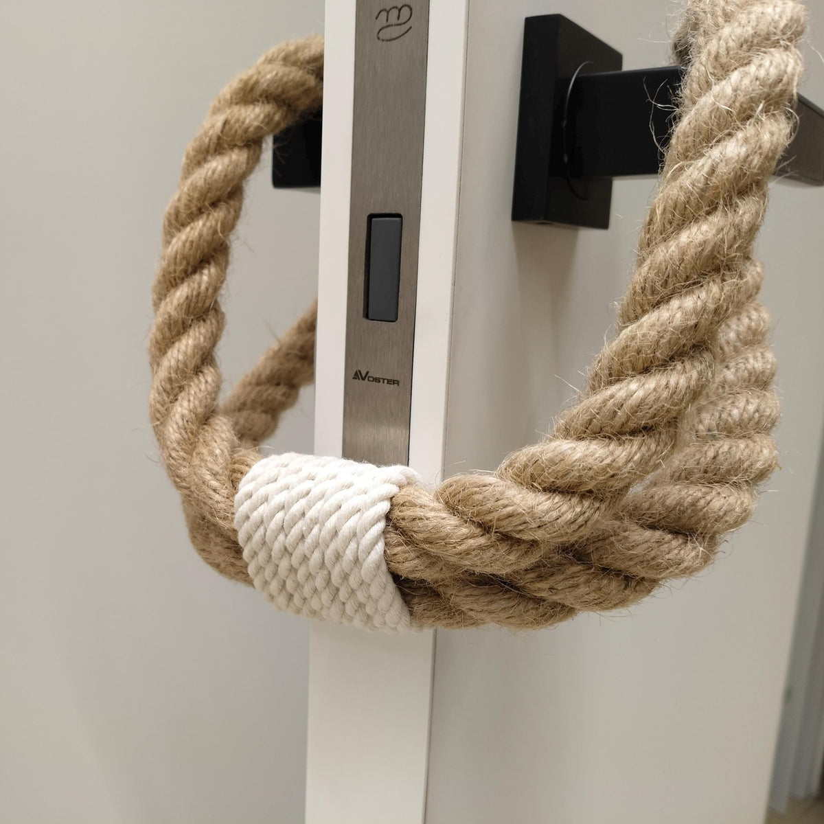 Nautical-style rope handle on a door with a white background